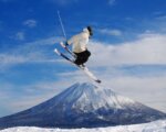 Skier jumping over mt yotei